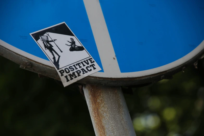 a sticker on the side of a blue and white traffic sign