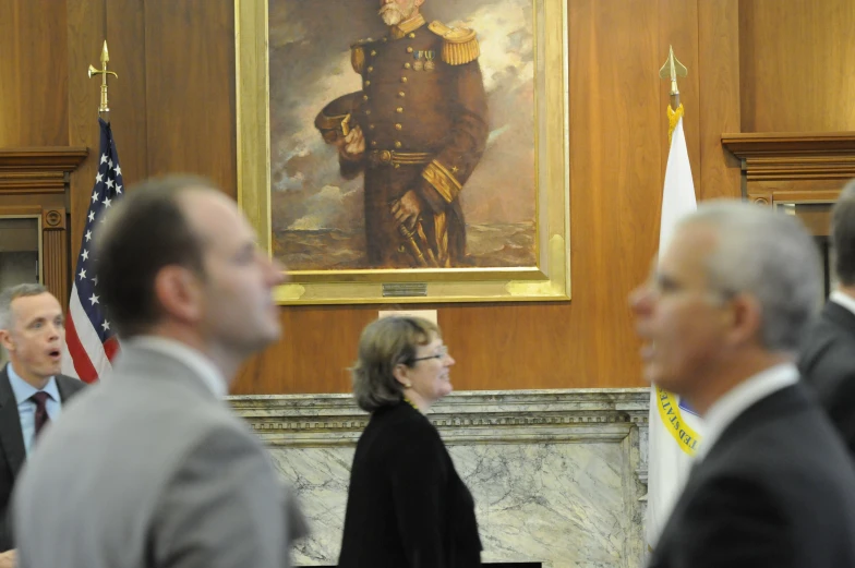 several people are standing next to each other in a meeting room