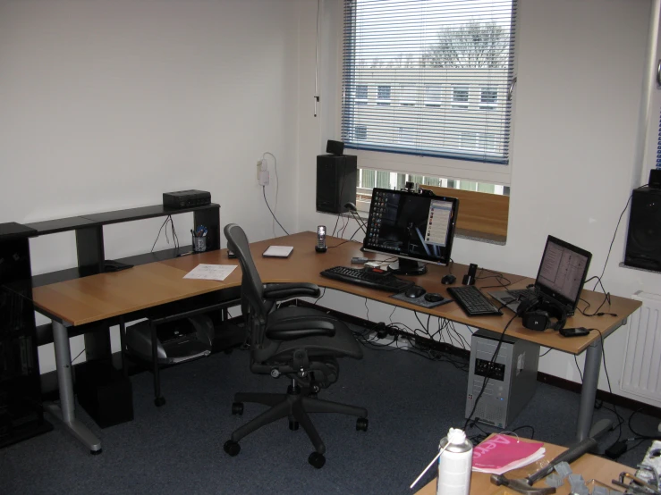 a corner desk with multiple computers on it