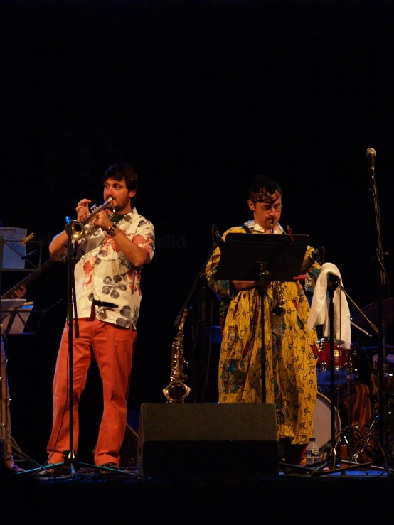 a band playing on stage at night with a man and woman