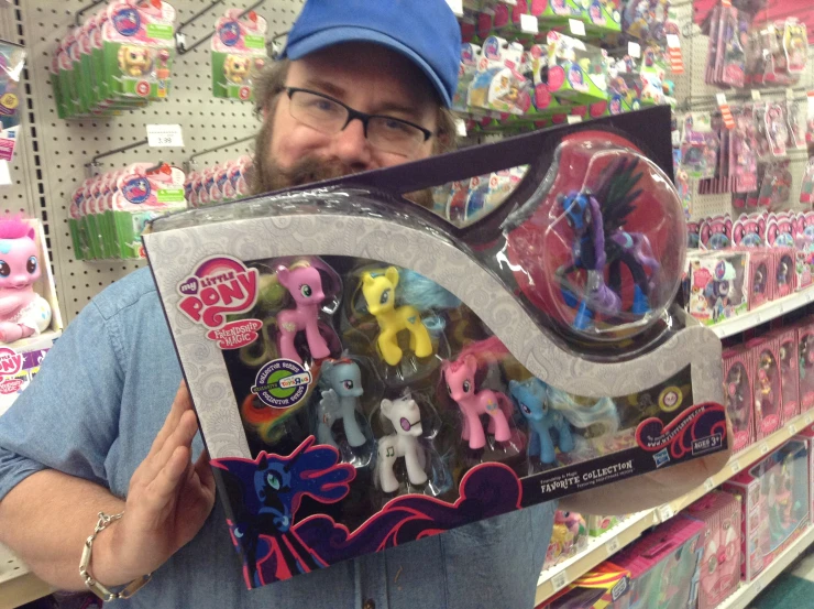 man holding up an assortment of little pony toys