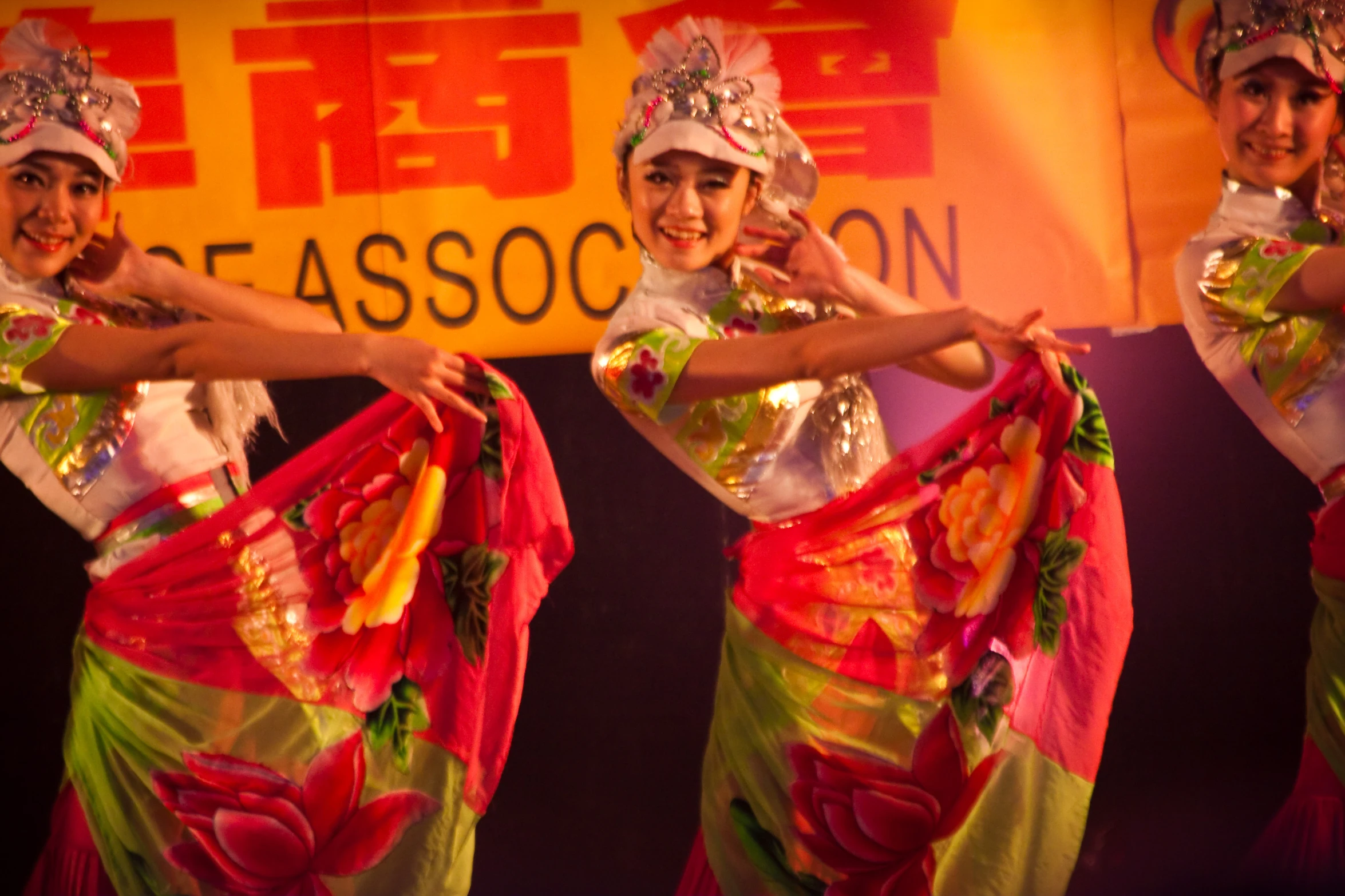 four ladies in costume holding onto some colorful fabric