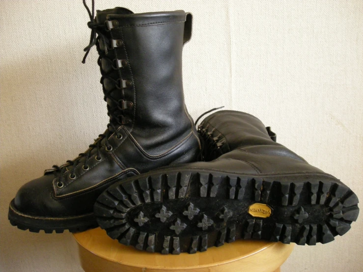 a pair of military style boots on a small stand