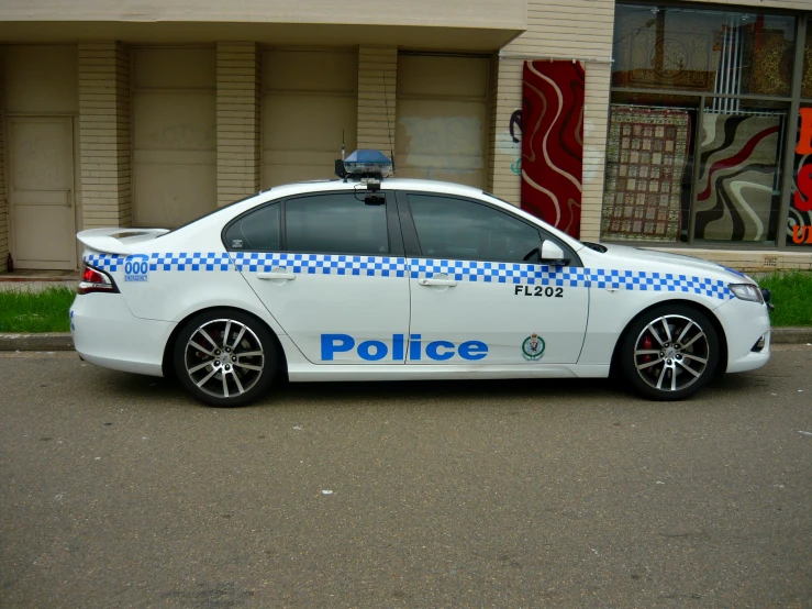 the police car is parked on the street near the building