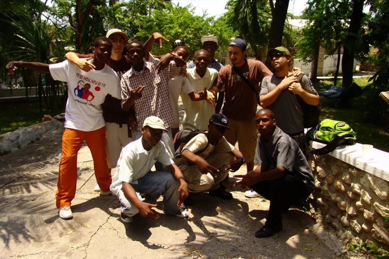 many guys standing and posing in a park