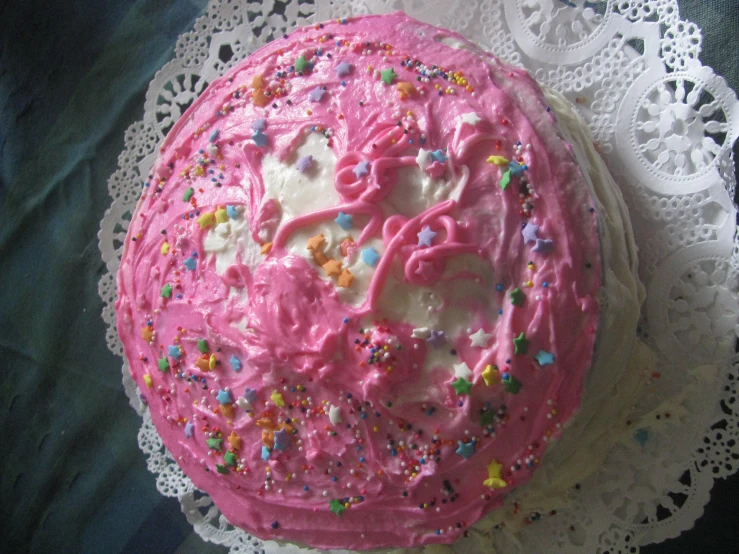 a cake with white frosting and pink icing decorated with bows