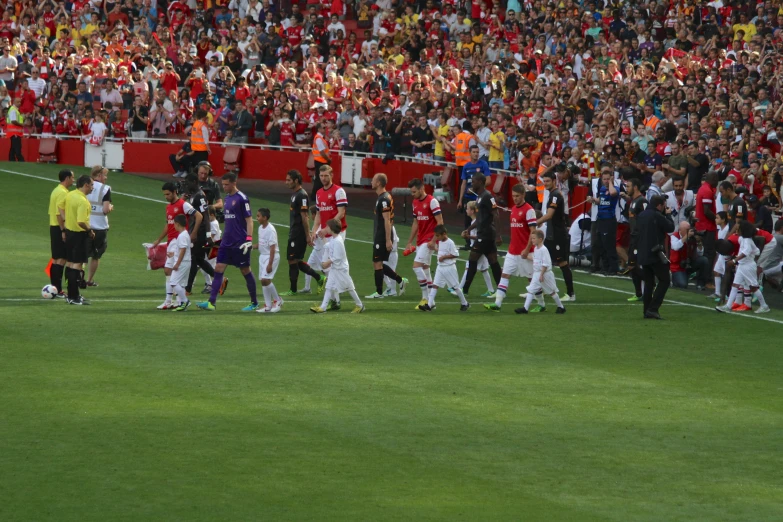 group of soccer players standing together and talking on the field