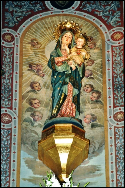 a statue of mary holding a child and surrounded by other images