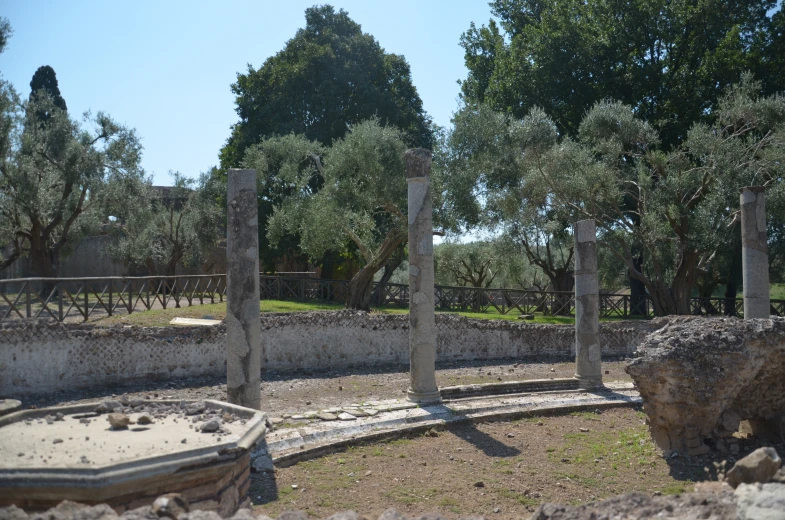 three stone blocks sitting near the water and trees