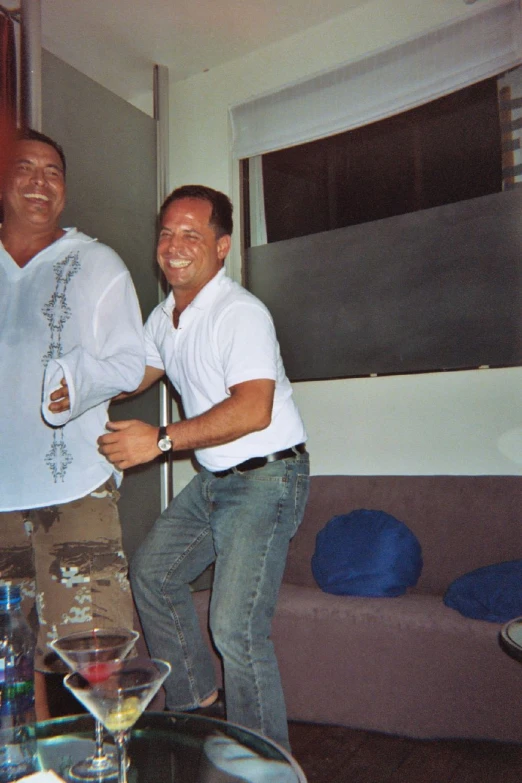 two men smiling and holding onto a metal object