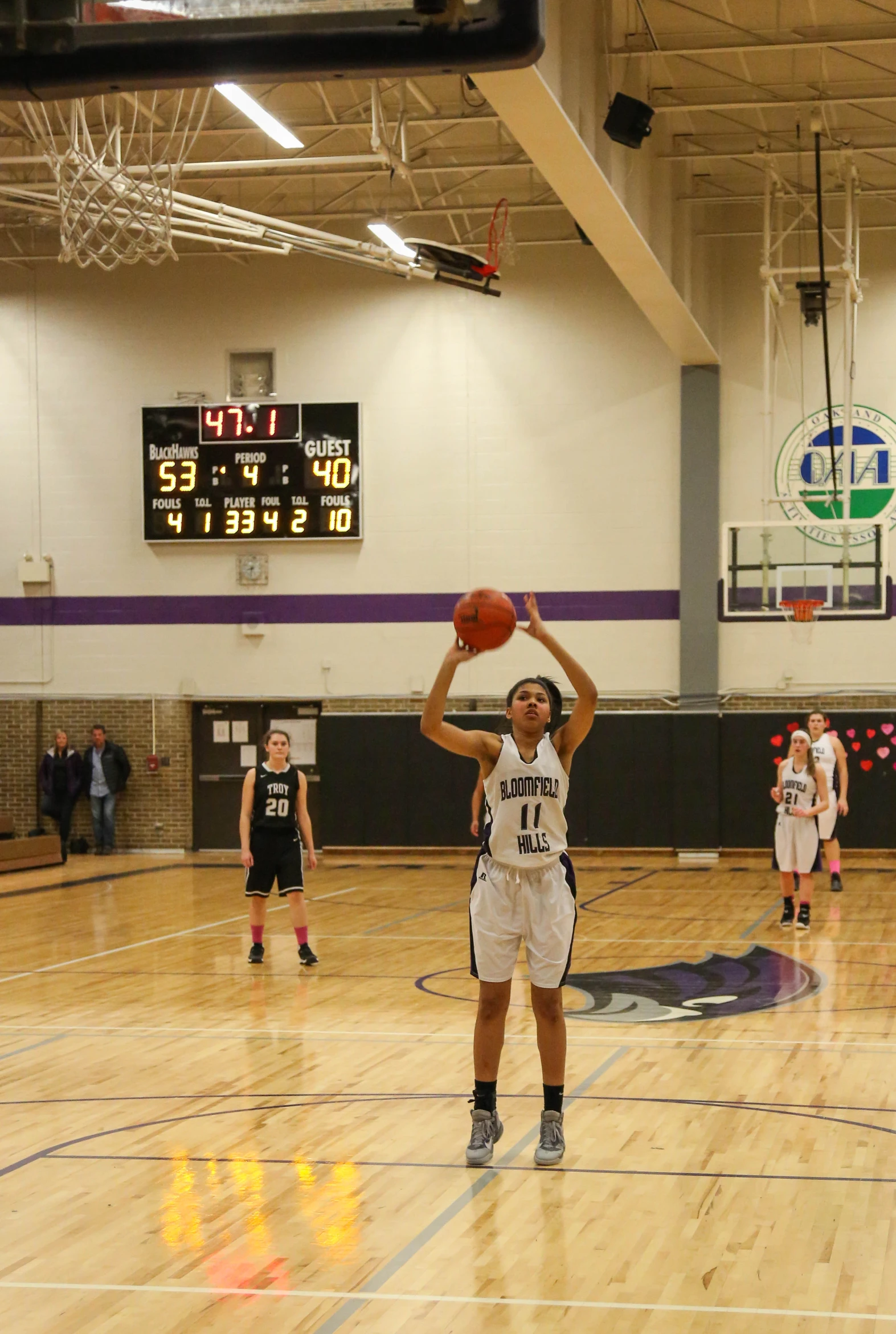 a basketball player holding a ball in an indoor court