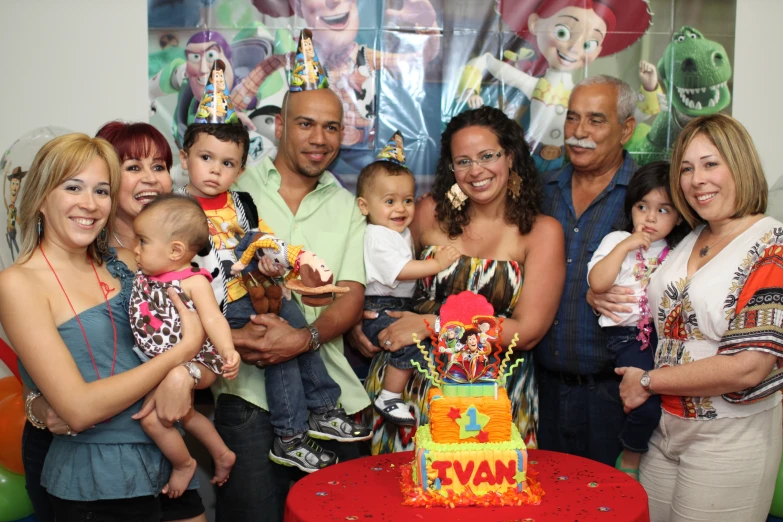 a group of people and their babies posing with a cake