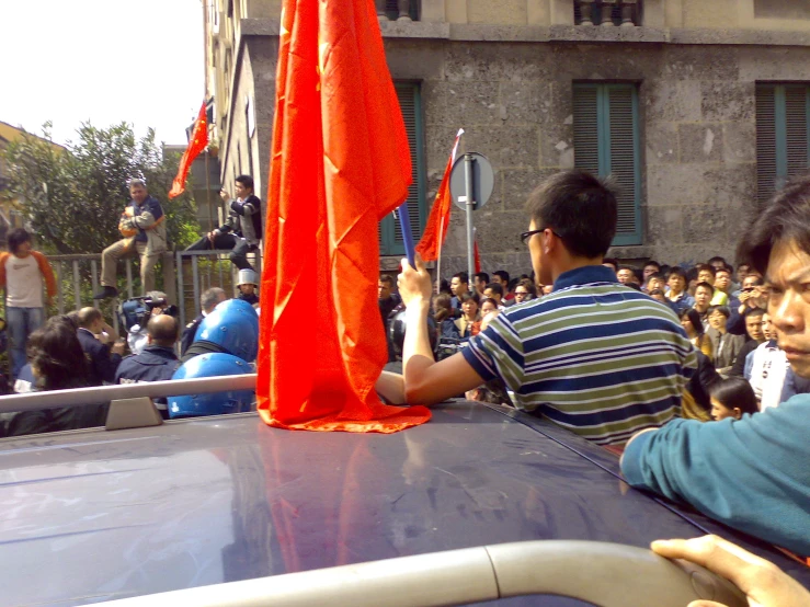 a man holding an orange umbrella in the street