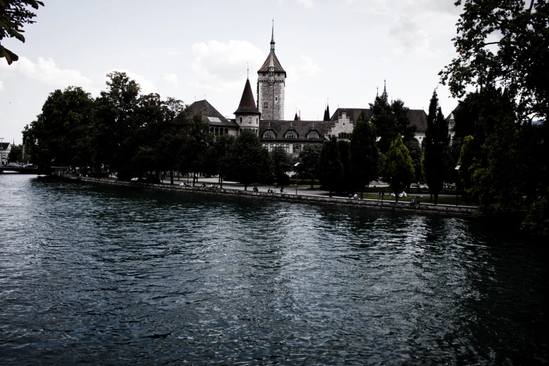 an old castle is sitting on the side of a river