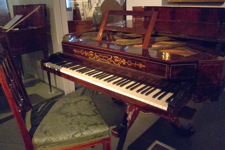 the old piano is sitting next to a chair