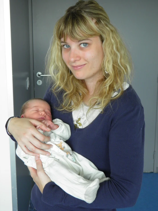 a women is holding her baby outside of the house