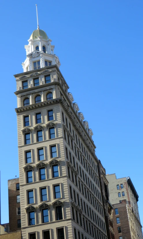 the very tall building is next to several other buildings