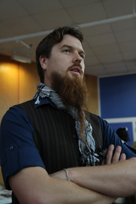 a young man in a vest and neck tie with a long beard