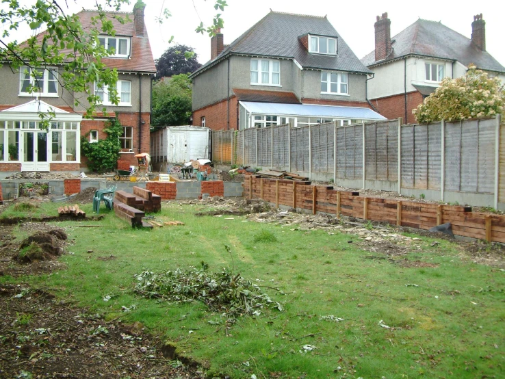 a garden with green grass, bricks, and brick planters