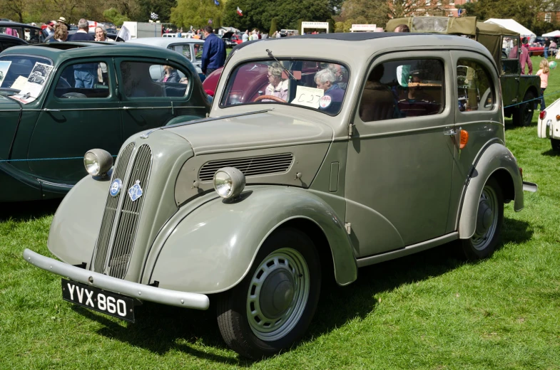 two older vintage cars in the middle of a field