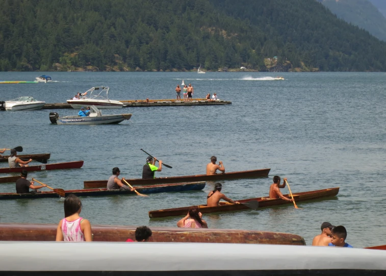 many people are rowing canoes in the water