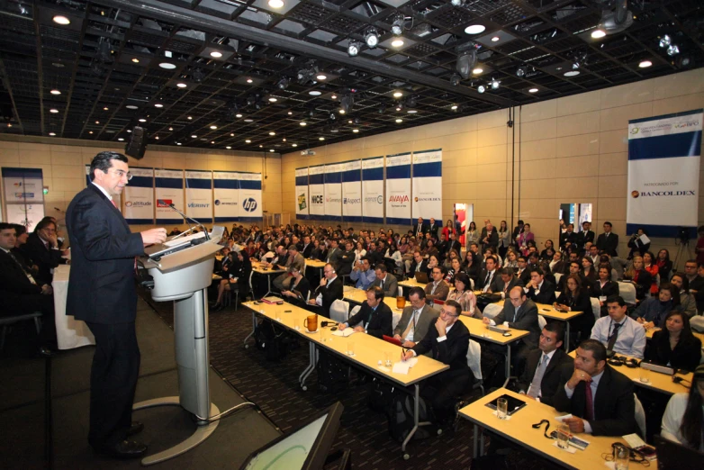 the man is giving a speech to people in suits