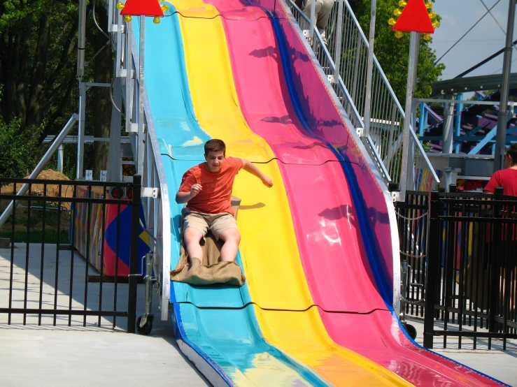 a man riding a colorful slide at a park