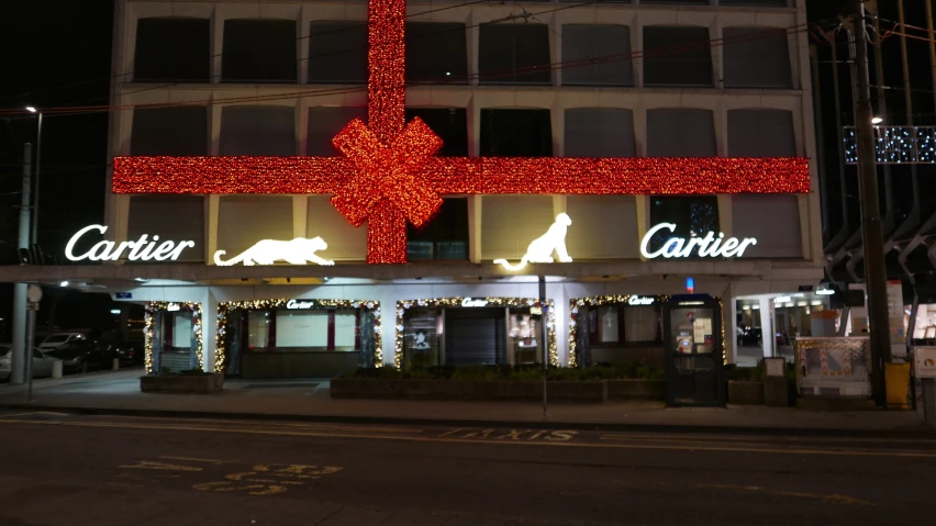 large lighted cross and lights of christmas trees