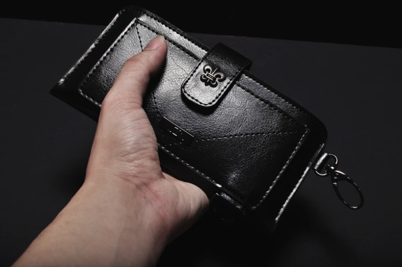 a person is holding out a black wallet