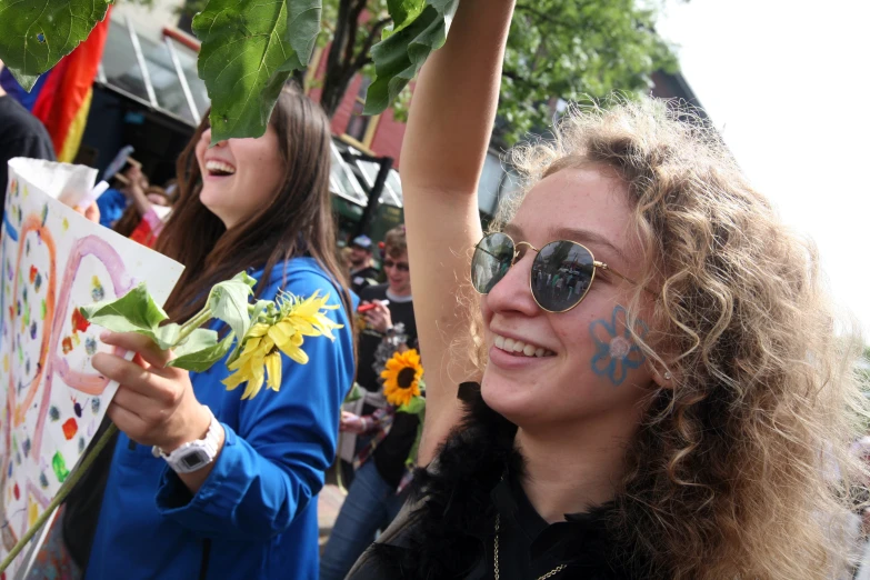 two women are holding flowers at the same time