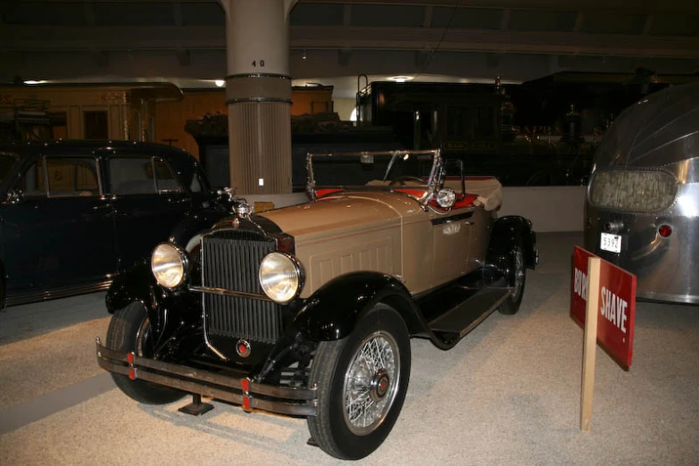 an antique vehicle and a black car on display