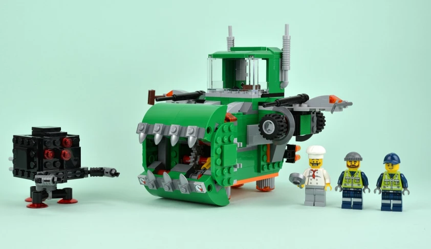 a green and white toy with a green tank and people