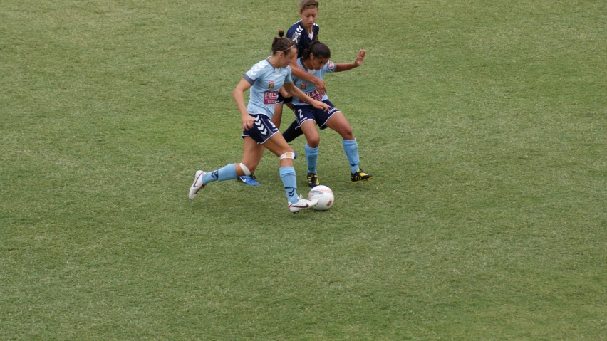 two female soccer players fight for control of the ball