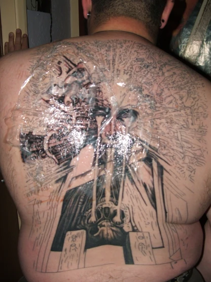 a man's back is covered in graffiti with writing