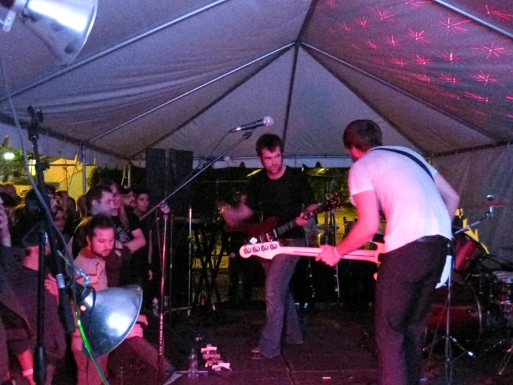 some people and a band under a tent