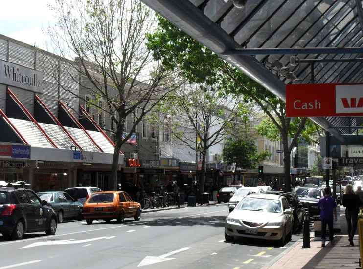 a city street filled with cars, pedestrians and buildings