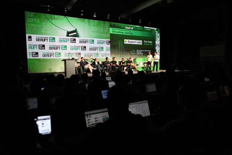 a group of people that are on a stage with laptops