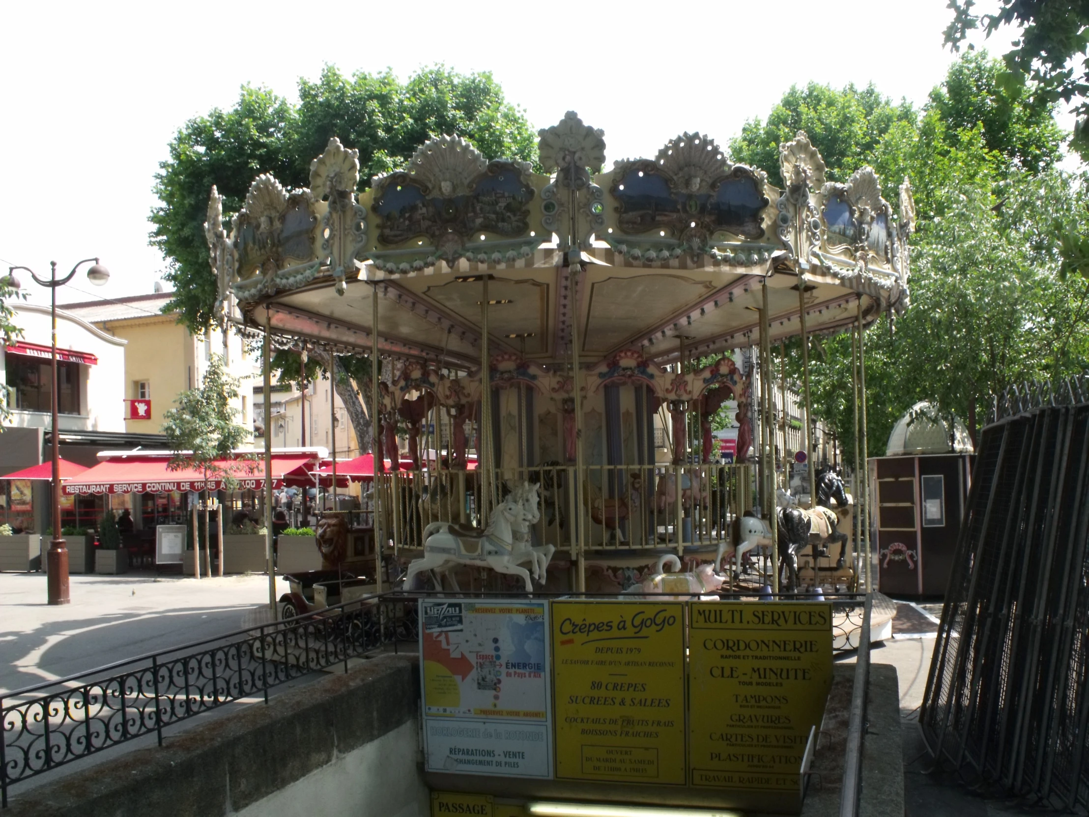 the carousel is sitting next to a fence in the park