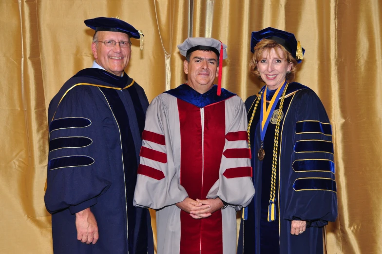 four people in gowns stand together outside