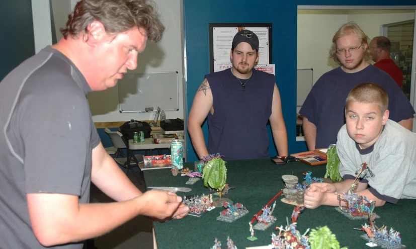 a group of men standing around a table