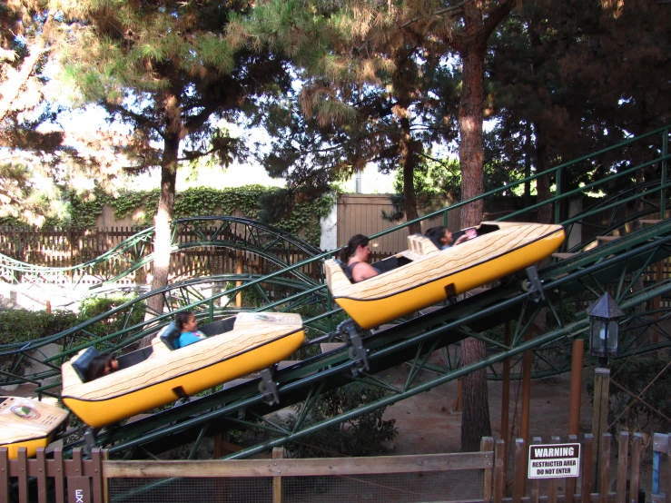 a couple of yellow boats ride down an obstacle