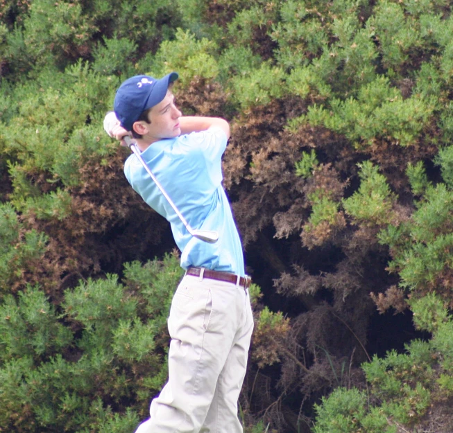 a man teeing off from the side on the green course