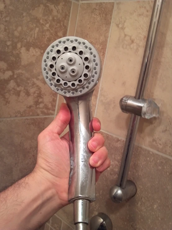 someone holding a shower head in their hand