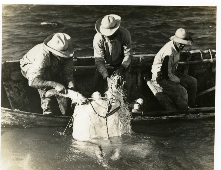 four men in hats are on a boat in the water