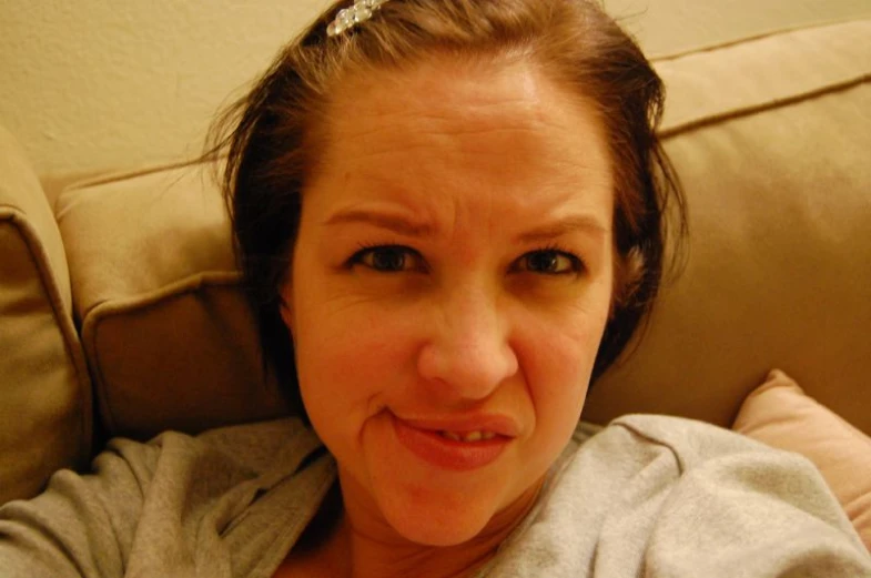 woman making a silly face sitting on a couch