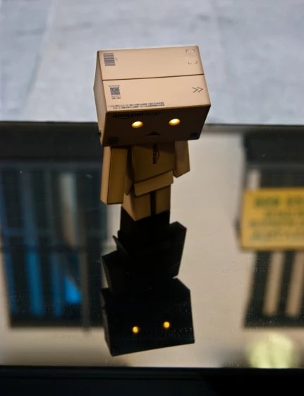 a small robot on a table near some electronics