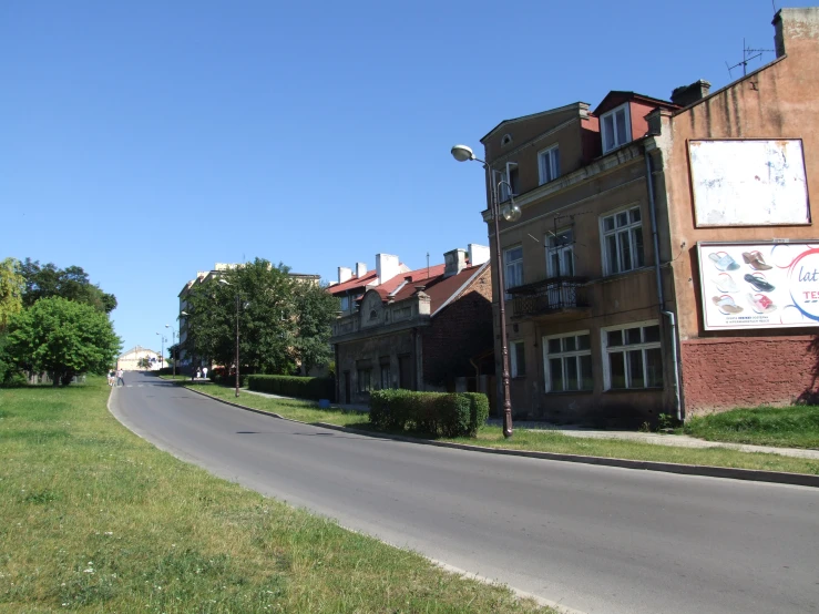 a curvy road lined with buildings in the suburbs