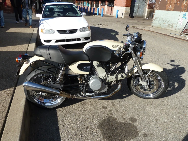 an old bike is parked next to the white car