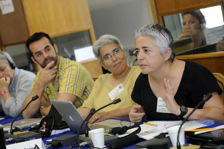 people listening at table on laptop computers