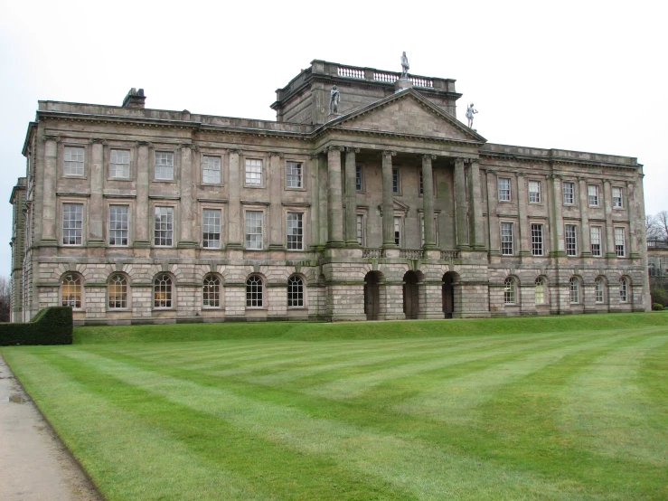 large stone building on grassy lawn with grass edging